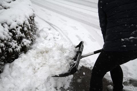 Morgenlage: Person beim Schneeschippen