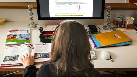 Ein Kind löst am Computer Schulaufgaben.