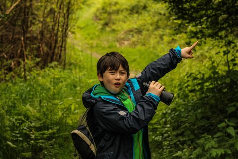 Eine Junge mit Fernglas weist den Weg
