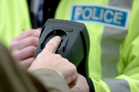 Ein Beamter der Verkehrspolizei demonstriert einen mobilen Fingerabdruckanalysator