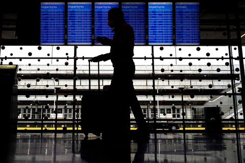Ein Reisender trägt eine Gesichtsmaske, während er durch Terminal 3 am O'Hare International Airport in Chicago geht.