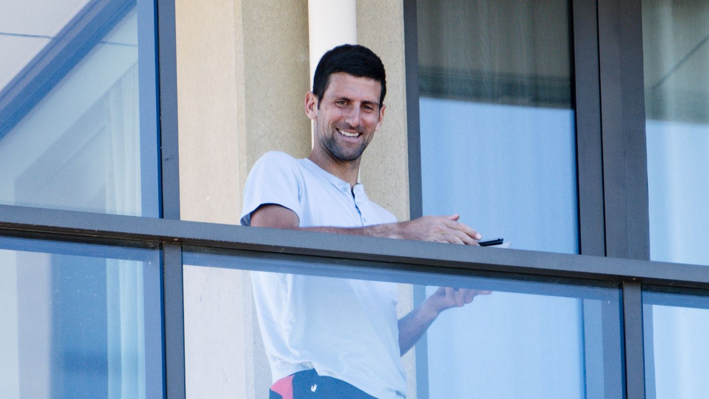 Tennisspieler Novak Djokovic aus Serbien steht auf einem Balkon der Unterkunft "The M Suites" in North Adelaide und schaut jungen Fans beim Tennisspielen zu. 
