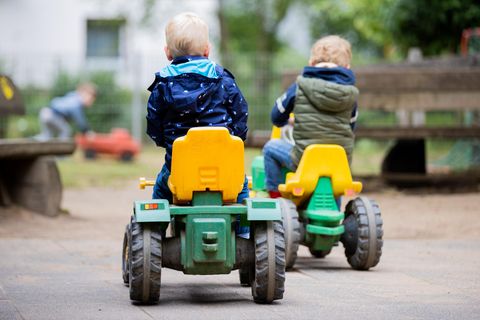 Zwei Kleinkinder spielen im Garten eines Kindergartens.