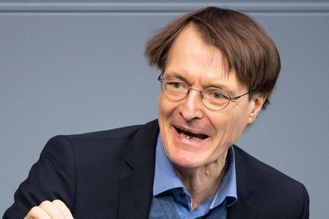 SPD-Gesundheitsexperte Karl Lauterbach steht in blauem Anzug am Rednerpult im Bundestag und gestikuliert mit der rechten Hand