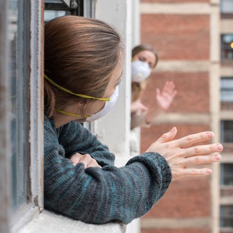 Nachbarn winken sich aus dem Fenster zu