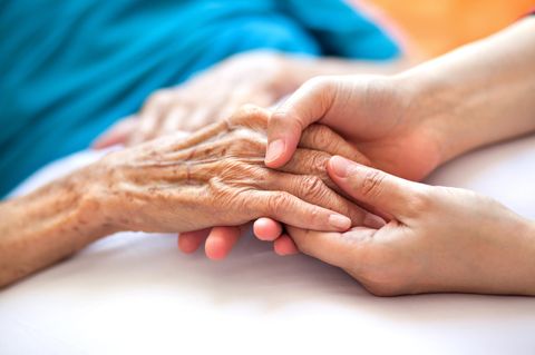 Altenpflege: Eine junge Frau hält die Hand einer älteren Frau