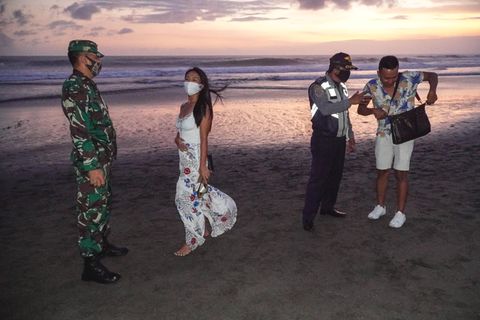 Kontrolle am abendlichen Strand: Masken-Check am Canggu Beach auf der Insel Bali