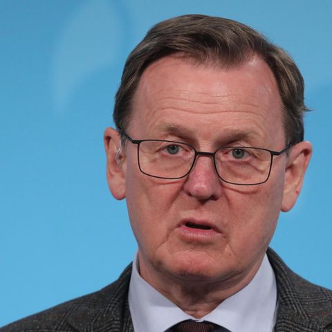 Bodo Ramelow - ein Mann mit Brille und dunkelblondem Seitenscheitel -  spricht vor einer blauen Wand in ein Mikro des MDR