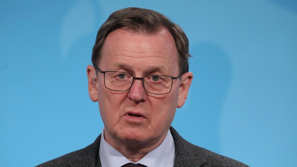 Bodo Ramelow Ministerpräsident Thüringen Bodo Ramelow - ein Mann mit Brille und dunkelblondem Seitenscheitel - spricht vor einer blauen Wand in ein Mikro des MDR