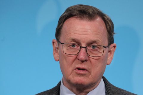 Bodo Ramelow - ein Mann mit Brille und dunkelblondem Seitenscheitel -  spricht vor einer blauen Wand in ein Mikro des MDR