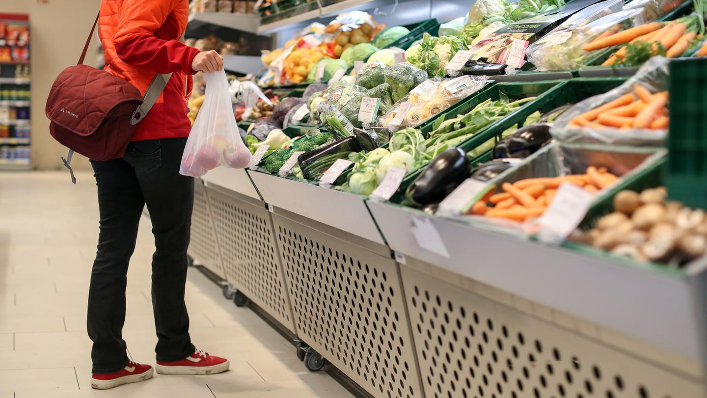 Eine Kundin steht in der Obst- und Gemüseabteilung in einem Supermarkt