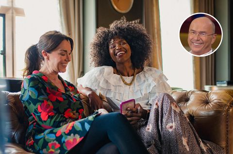 Zwei Frauen sitzen auf einem Sofa und lachen