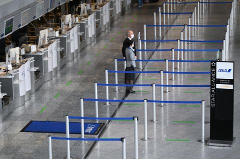 Mitarbeiter einer Fluggesellschaft stehen vor leeren Abflugschaltern am Frankfurt Airport