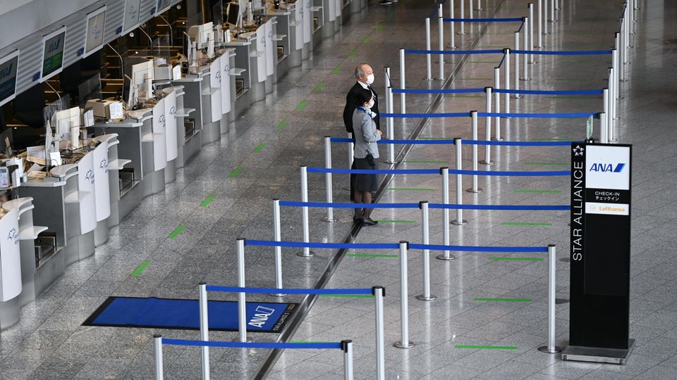 Mitarbeiter einer Fluggesellschaft stehen vor leeren Abflugschaltern am Frankfurt Airport