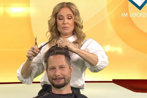 Katja Burkard schneidet einem Reporter die Haare