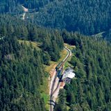 Hochschneeberg/Baumgartner – Osterreich  In der Nähe von Wien gibt es eine Zahnradbahn, sie führt von Puchberg auf den 1796 Meter hohen Hochschneeberg. Sie hat eine Spurweite von 1000 Millimeter und ist mit einer Länge von 9,7 Kilometern die längste Zahnradbahn Österreichs. Typisch für die aktuelle Schneebergbahn sind die bunten Salamander-Triebwagen, die seit 1999 in Dienst stehen und die alten Dampflokomotiven weitgehend abgelöst haben. Die Aufnahme zeigt zwei solcher Triebwagen, die sich in der Kreuzungsstation Baumgartner begegnen.