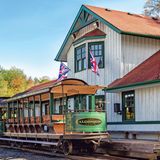 Huntsville – Kanada  In Huntsville im kanadischen Bundesstaat Ontario steht im Oktober 2019 abfahrbereit der "Portage Flyer" in der Rotary Village Station. Die kleine Bahn ist ein Teil des "Muskoka Heritage Place" und erinnert an eine Kleinbahn, die zwischen 1904 und 1959 zwischen Nord- und Süd-Portage verkehrte. Die heutige Touristenbahn besitzt mehrere Aussichtswagen sowie je eine Dampf- und Diesellokomotive, ein Museum ist angegliedert.
