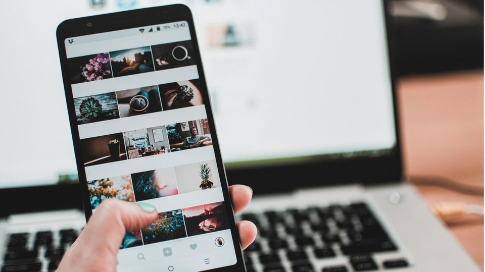 Eine Frau scrollt auf dem Handy durch Instagram