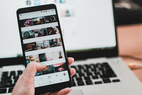 Eine Frau scrollt auf dem Handy durch Instagram
