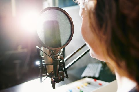 Eine Person sitzt vor einem Radio-Mikrofon