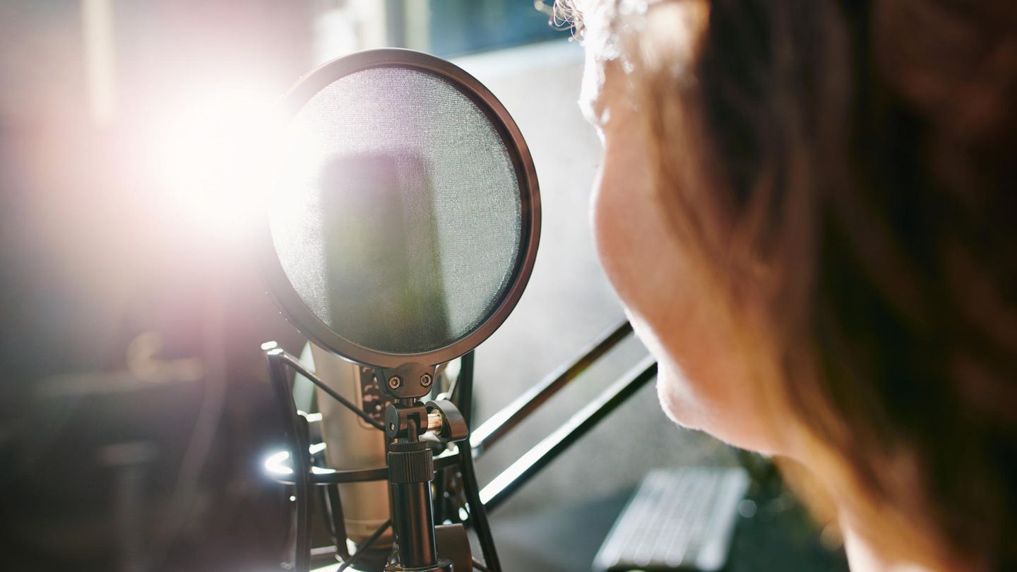 Eine Person sitzt vor einem Radio-Mikrofon