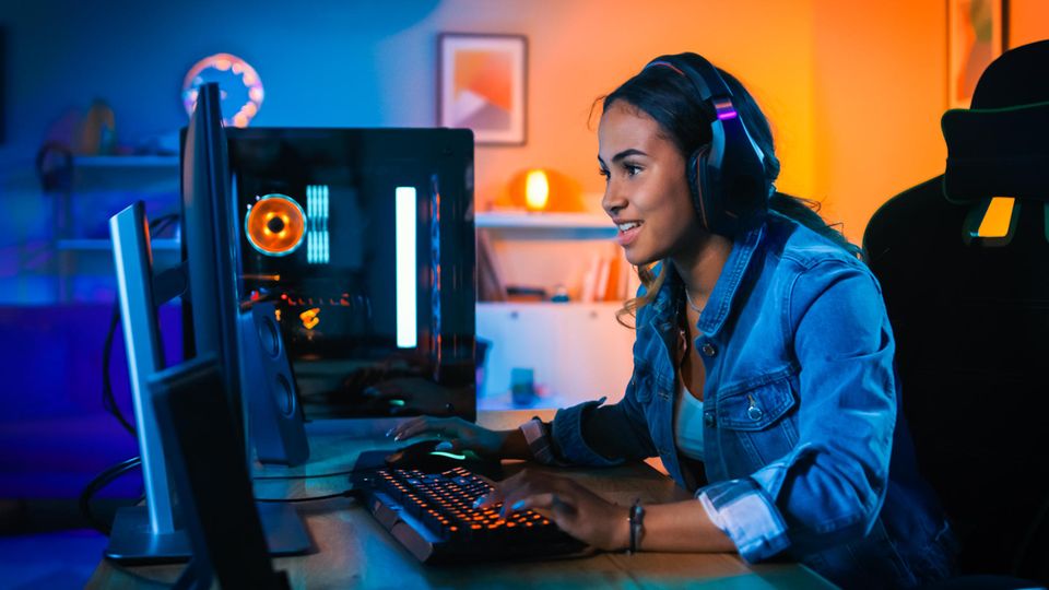 Eine Frau spielt am PC und schaut auf den IPS Monitor