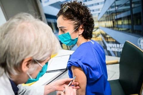 Eine Ärztin impft eine Pflegegruppenleiterin der Covid-19-Intensivstation C1 am Uniklinikum Frankfurt