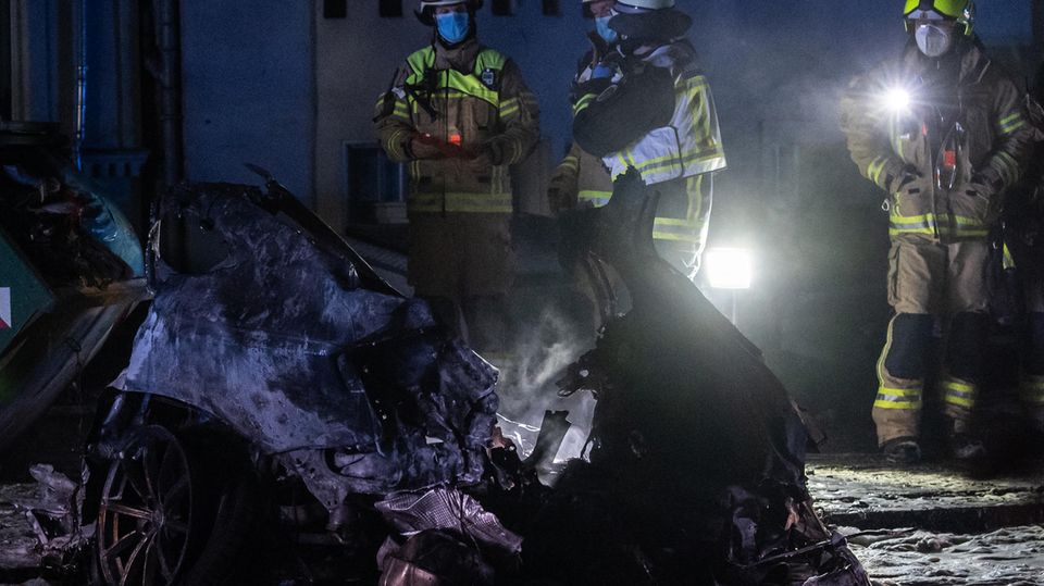 Nachrichten Deutschland Berlin Einsatzkräfte der Feuerwehr stehen am Treptower Park neben einem Autowrack