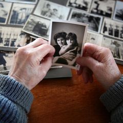 Altenpflege: Eine ältere Frau sieht sich alte Fotos an