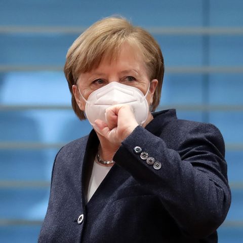 Angela Mekrel mit Maske und Faust vor der Maske