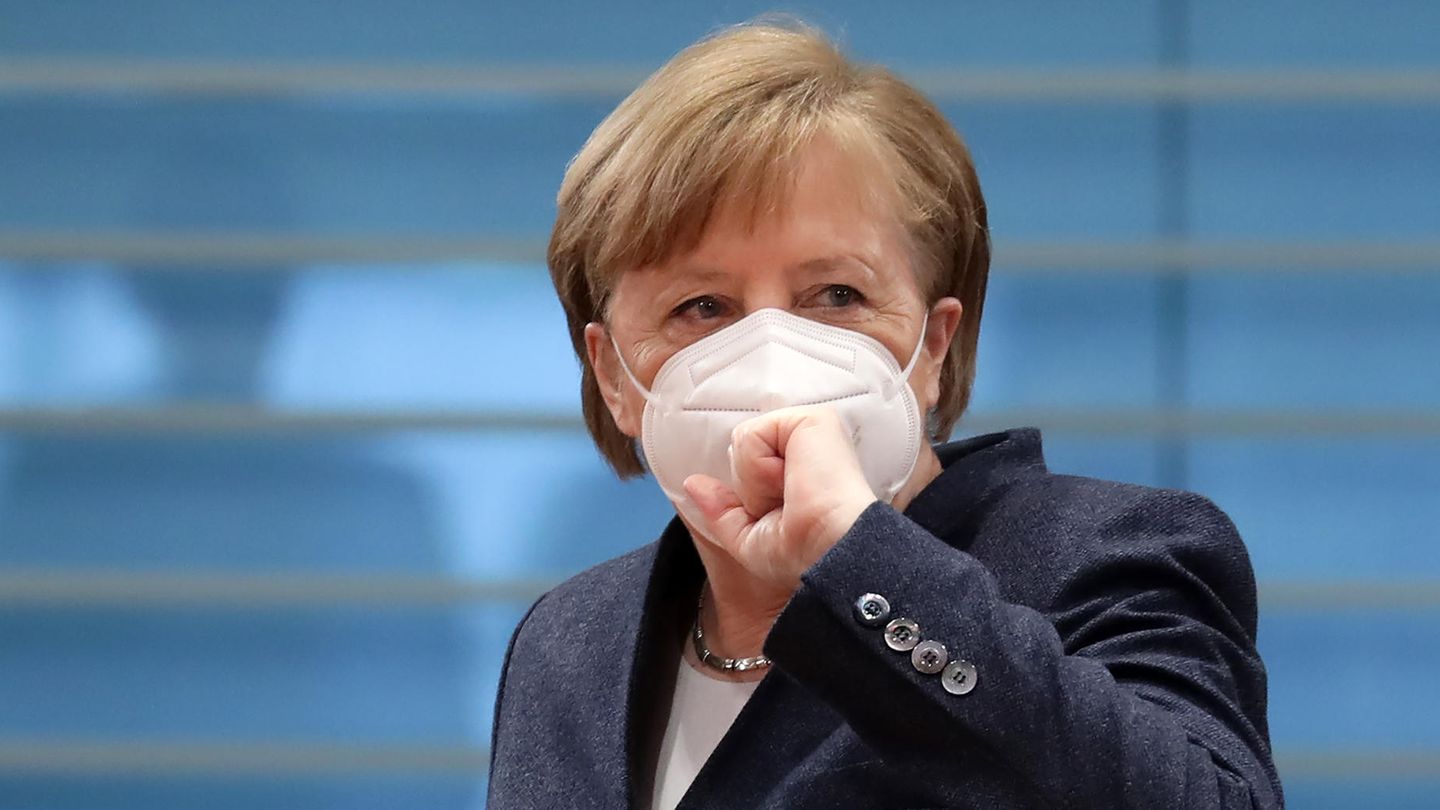 Angela Mekrel mit Maske und Faust vor der Maske