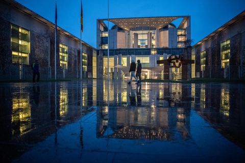Berlin: Fußgänger laufen im Regen am Bundeskanzleramt vorbei. Dort tagte am Abend der Koalitionsausschuss.