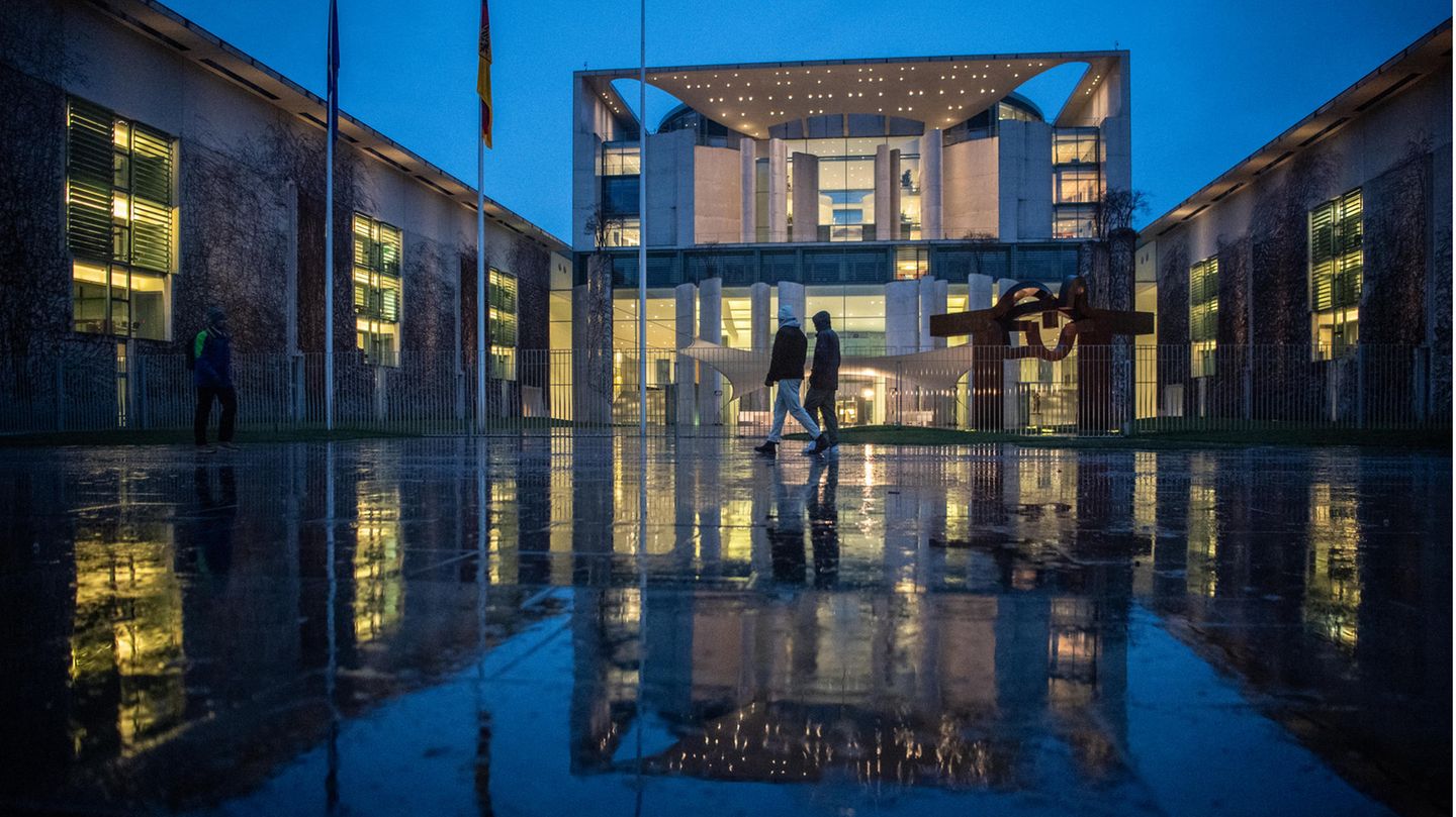 Berlin: Fußgänger laufen im Regen am Bundeskanzleramt vorbei. Dort tagte am Abend der Koalitionsausschuss.