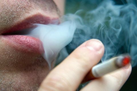 Eine Person atmet Zigarettenrauch aus