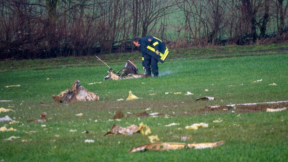 Nachrichten Deutschland Sefferweich Ein Polizist markiert den Bereich der Trümmerteile nach dem Absturz eines Kleinflugzeugs.