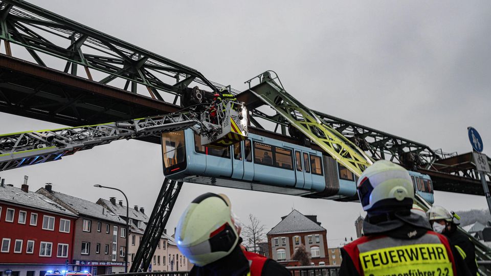 Schwebebahn Wuppertal Einsatzkräfte der Feuerwehr befreien mit einer Drehleiter Fahrgäste aus einem Wagen der Schwebebahn