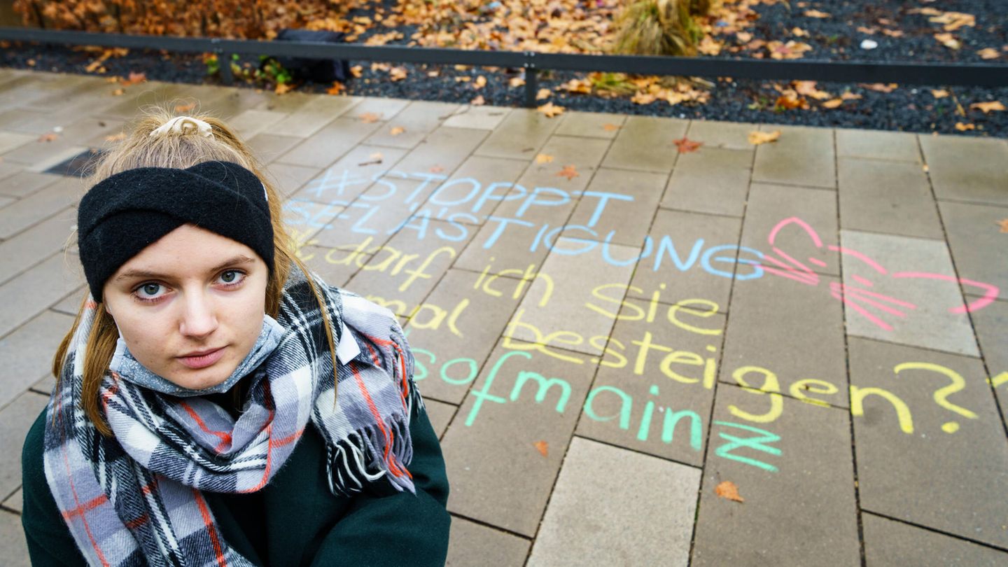 Melina Crispin, Aktivistin, kniet vor einem in Kreide aufgeschriebenem anzüglichen Kommentar