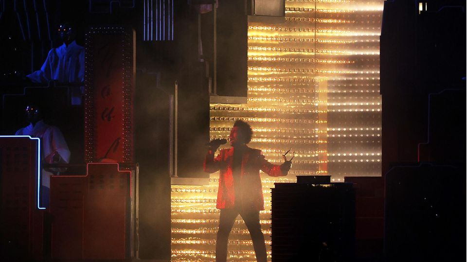 Komm ins Licht: Zu Beginn der Superbowl-Halbzeitshow in Tampa öffnet sich für Superstar The Weeknd die Tribüne. Der Sänger betritt durch einen Lichtkegel die Bühne und zeigt bei seinem 13-minütgen Auftritt eine spektakuläre Show mit vielen technischen Raffinessen.
