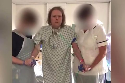 Jason Kelk wird von zwei Krankenschwestern des St James Hospital gestützt