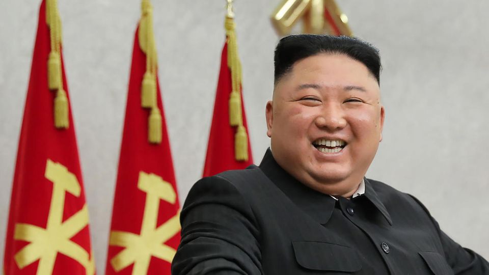Kim Jong Un Nordkorea Kim Jong Un - ein übergewichtiger Asiate mit rundem Kopf und schwarzem Bürstenschnitt - steht an einem Rednerpult und lacht