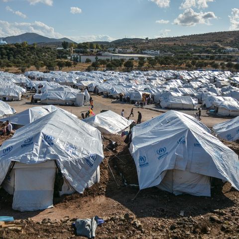 Migranten gehen nach starken Regenfällen durch das Flüchtlingslager "Kara Tepe"
