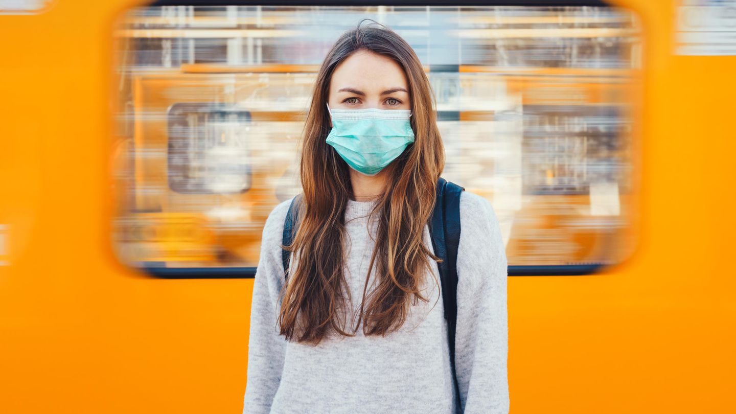 Coronavirus: Eine Frau mit Maske steht vor einer U-Bahn