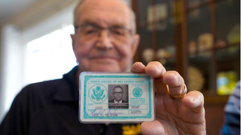 Paul Grisham hält seinen Navy-Ausweis von 1968 in seinem Haus in San Diego am 3. Februar 2021