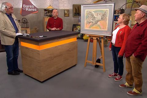 "Bares für Rares"-Experte Albert Maier erklärt in der ZDF-Trödelshow die Herkunft des Picasso-Bildes. Moderator Horst Lichter und das Besitzer-Ehepaar Franke hören zu. 