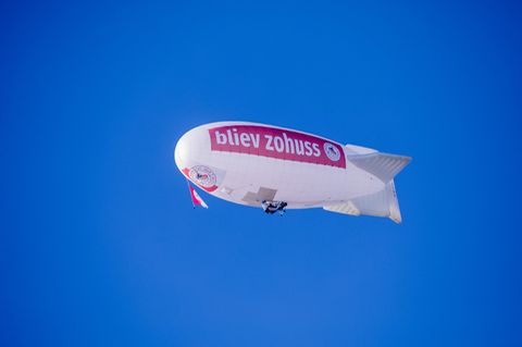Ein Zeppelin mit der Aufschrift «bliev zohuss» vom Karnevalscorps Rote Funken fliegt über die Kölner Altstadt.