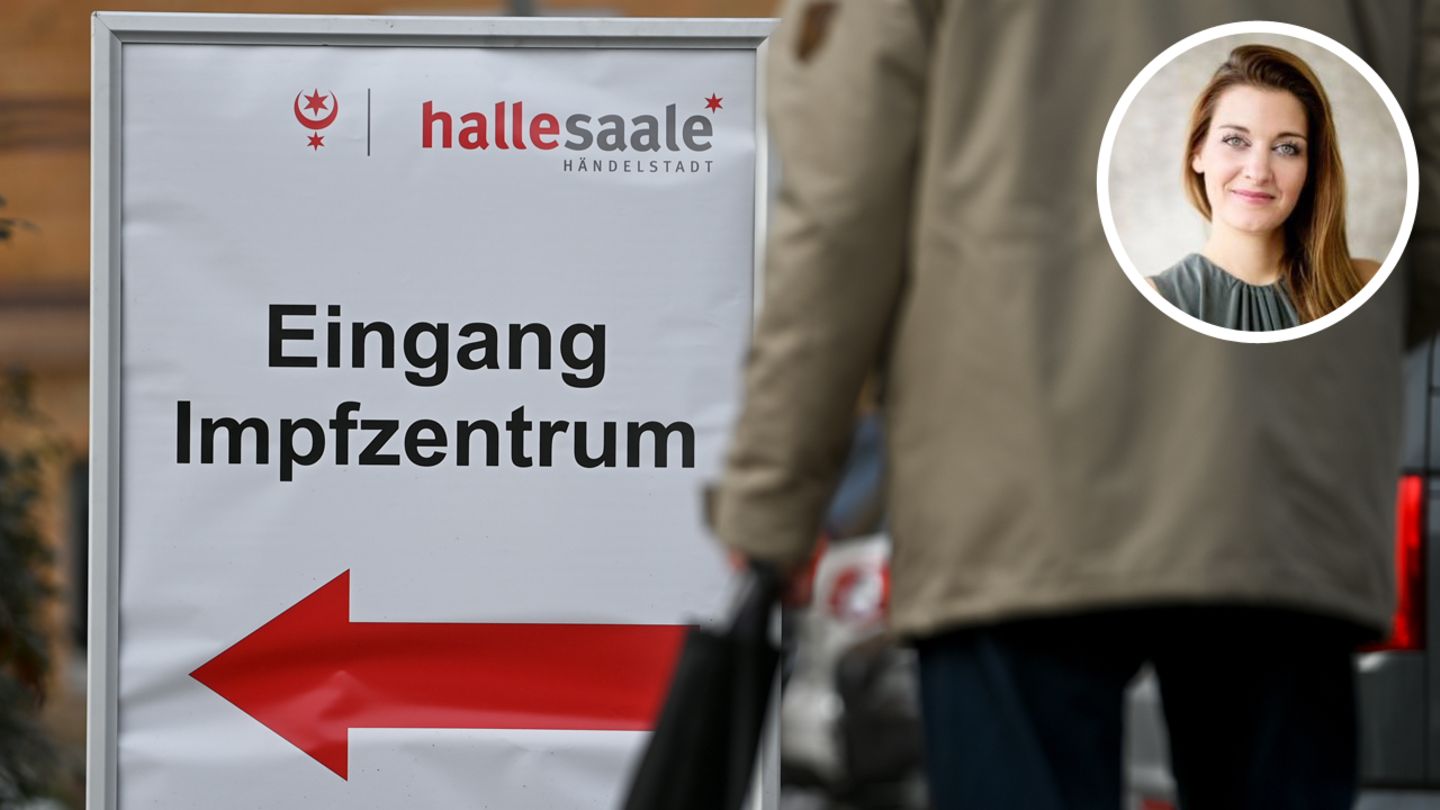 Ein Schild vor dem Impfzentrum in Halle an der Saale weist den Weg zum Eingang