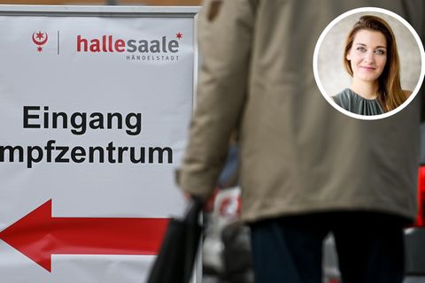 Ein Schild vor dem Impfzentrum in Halle an der Saale weist den Weg zum Eingang