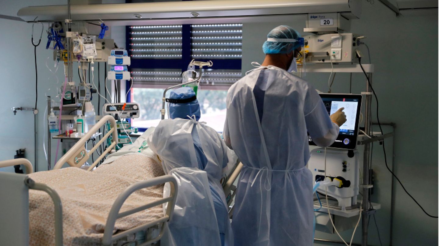 Eine Krankenschwester und ein Pfleger behandeln einen Patienten.