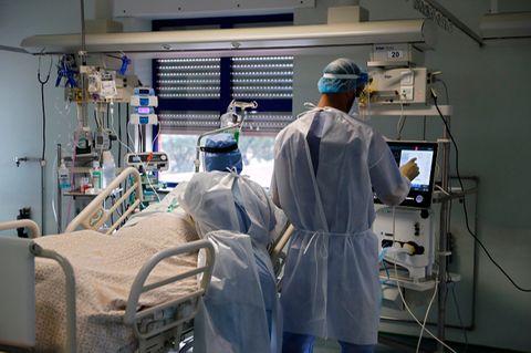 Eine Krankenschwester und ein Pfleger behandeln einen Patienten.