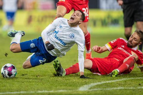 Amine Harit (l.) von Schalke 04 geht im Zweikampf mit Union Berlins Florian Hübner zu Boden